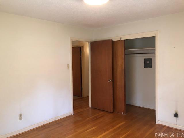 unfurnished bedroom featuring a closet, baseboards, and wood finished floors