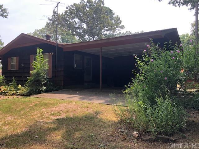 view of side of home featuring a carport and a lawn