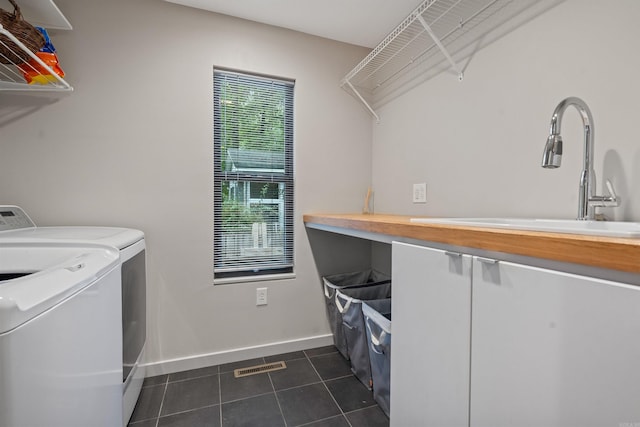 laundry area with visible vents, a sink, washer and clothes dryer, laundry area, and dark tile patterned flooring