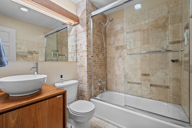 bathroom featuring combined bath / shower with glass door, toilet, vanity, and tile patterned flooring