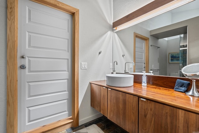 full bath featuring double vanity, baseboards, and a sink