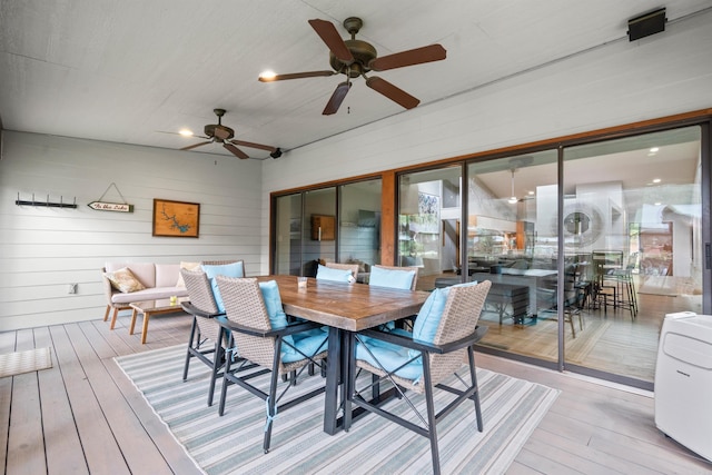 wooden deck featuring outdoor dining space and a ceiling fan