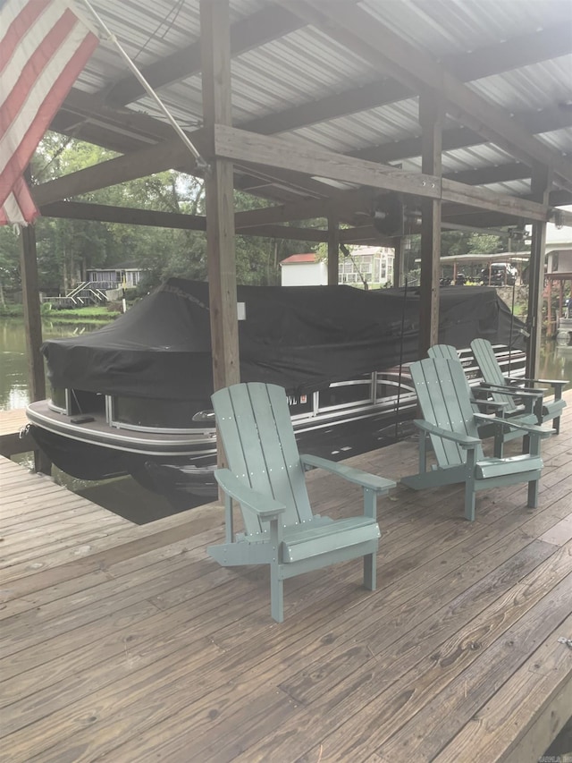 wooden deck with a water view, boat lift, and a dock