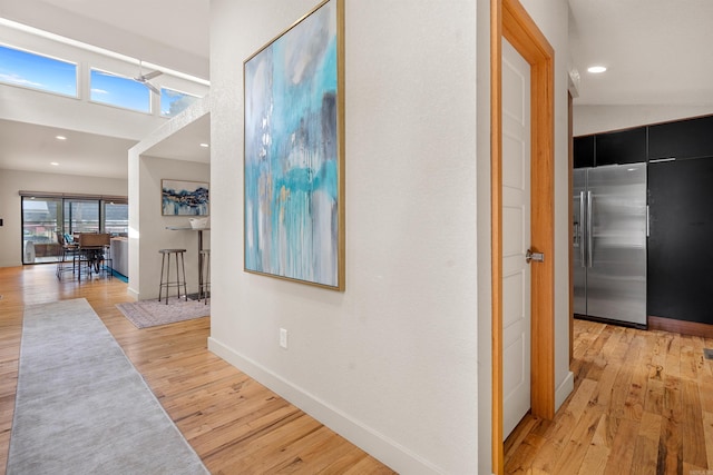 hallway featuring recessed lighting, baseboards, and light wood-type flooring