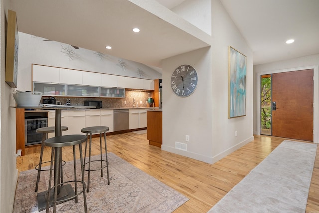 kitchen with beverage cooler, white cabinets, dishwasher, modern cabinets, and backsplash