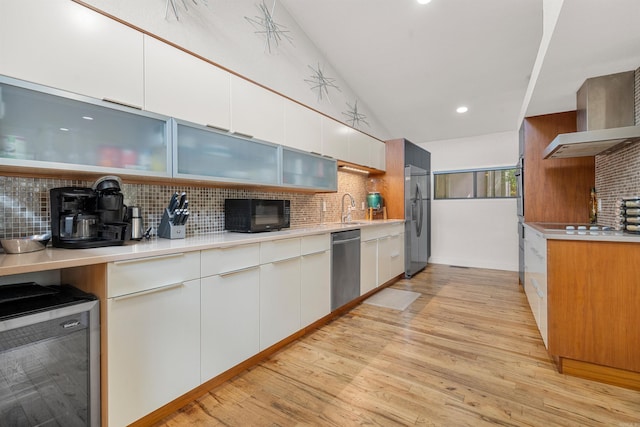 kitchen featuring wine cooler, light wood finished floors, appliances with stainless steel finishes, and tasteful backsplash