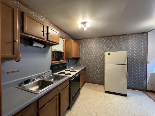 kitchen with wallpapered walls, freestanding refrigerator, ornamental molding, a sink, and electric range oven