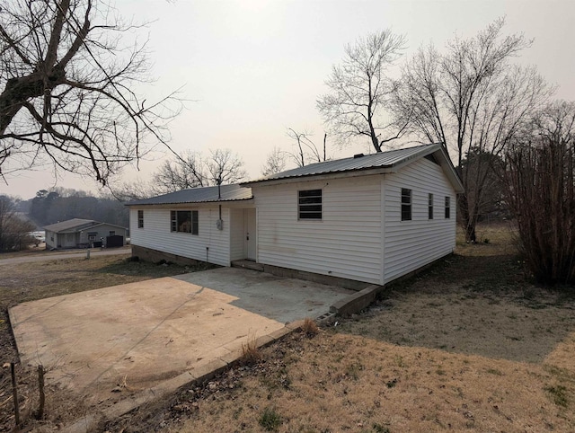 back of property featuring metal roof and a patio
