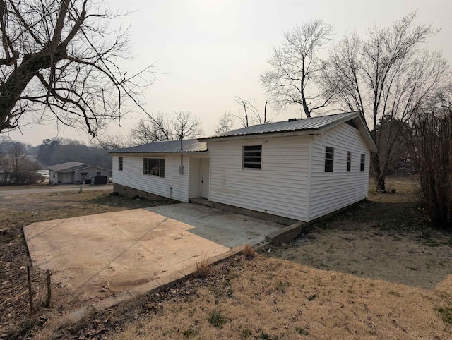 back of property featuring metal roof and a patio