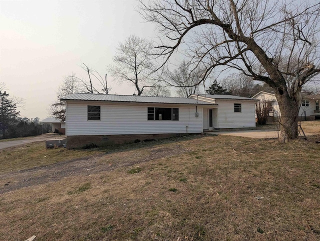 view of front of home featuring a patio, a front yard, metal roof, and crawl space