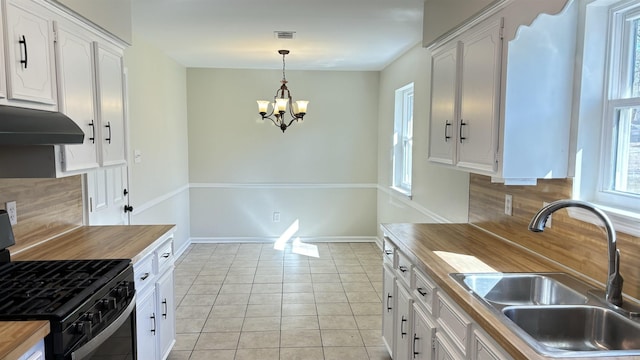 kitchen featuring a sink, butcher block countertops, black gas range, and under cabinet range hood