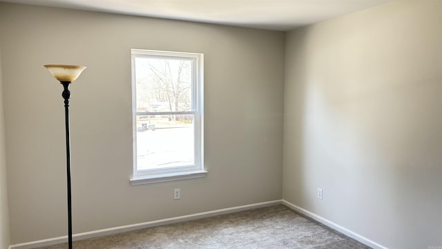 carpeted empty room featuring baseboards