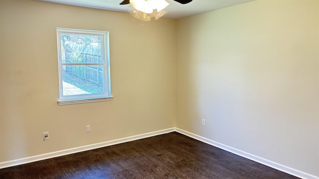 empty room with baseboards, dark wood-type flooring, and a ceiling fan