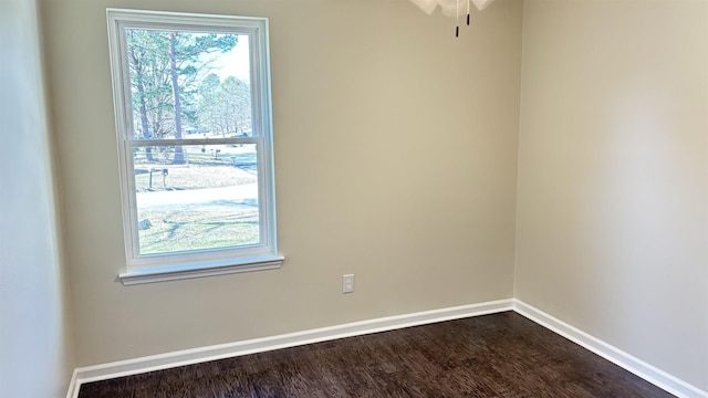 empty room featuring baseboards, dark wood-type flooring, and a ceiling fan