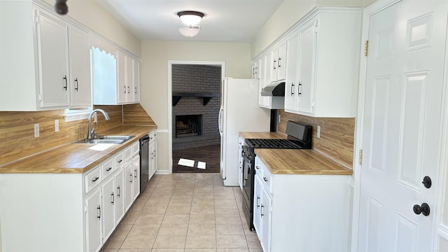 kitchen featuring under cabinet range hood, dishwasher, light tile patterned flooring, gas stove, and a sink