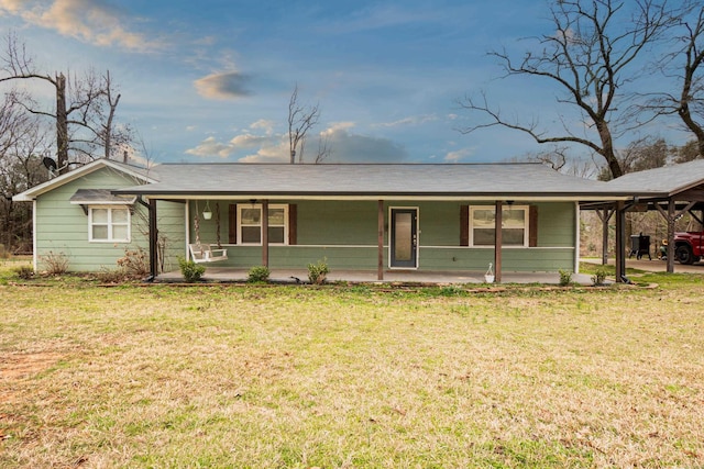 ranch-style house with a carport, covered porch, and a front lawn