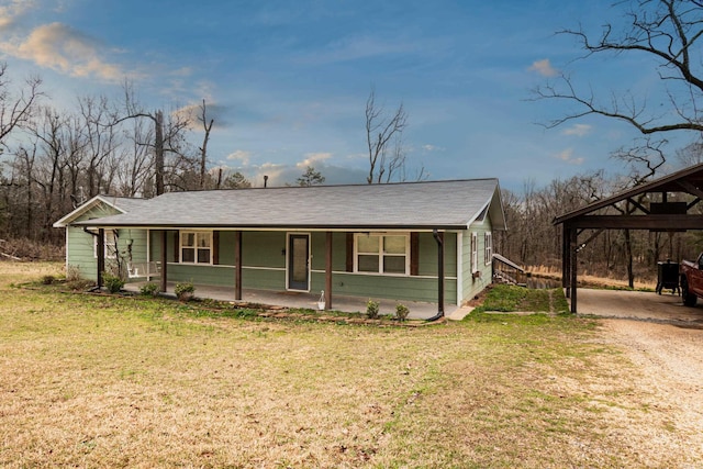 view of front of property featuring a carport, covered porch, a front yard, and dirt driveway