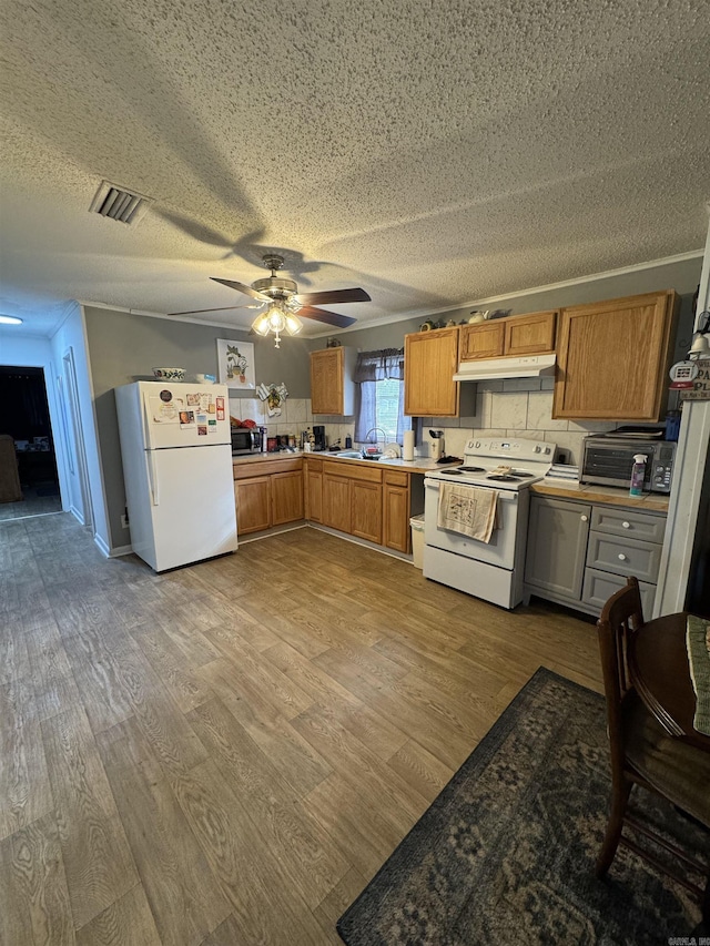 700 Thompson St, Mcgehee, AR 71654 - kitchen featuring visible vents, a sink, wood finished floors, white appliances, and ceiling fan