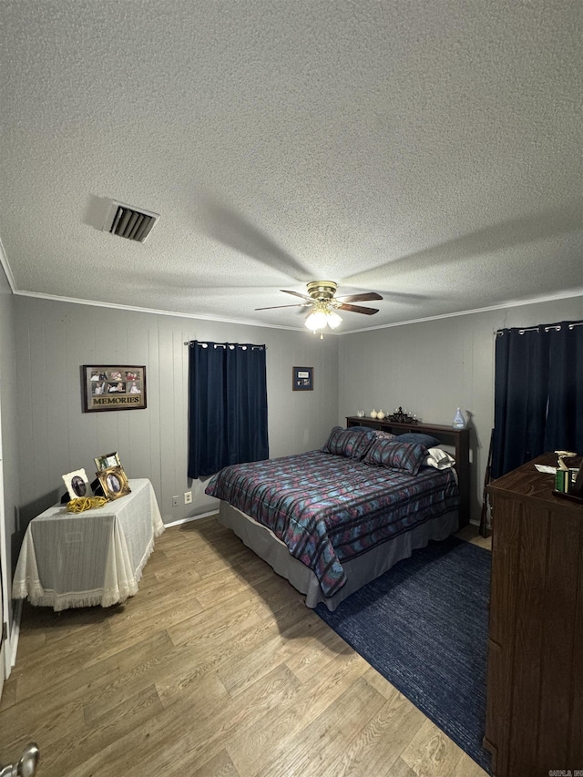 700 Thompson St, Mcgehee, AR 71654 - bedroom featuring visible vents, a textured ceiling, wood finished floors, and a ceiling fan
