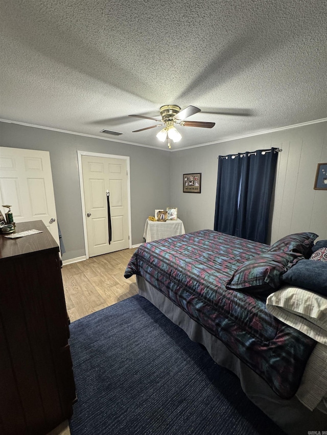 700 Thompson St, Mcgehee, AR 71654 - bedroom featuring visible vents, ornamental molding, a textured ceiling, light wood finished floors, and ceiling fan
