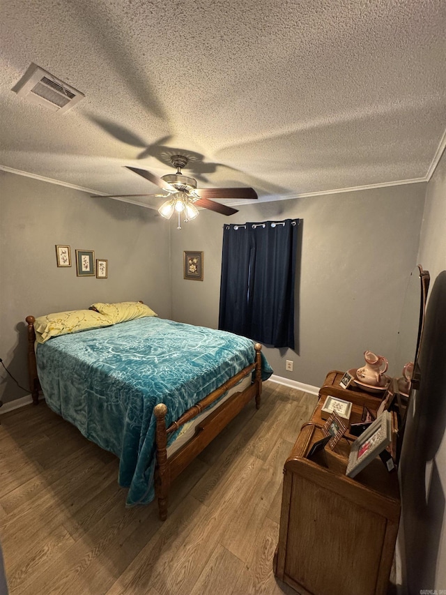 700 Thompson St, Mcgehee, AR 71654 - bedroom with visible vents, light wood-style flooring, a textured ceiling, and ornamental molding