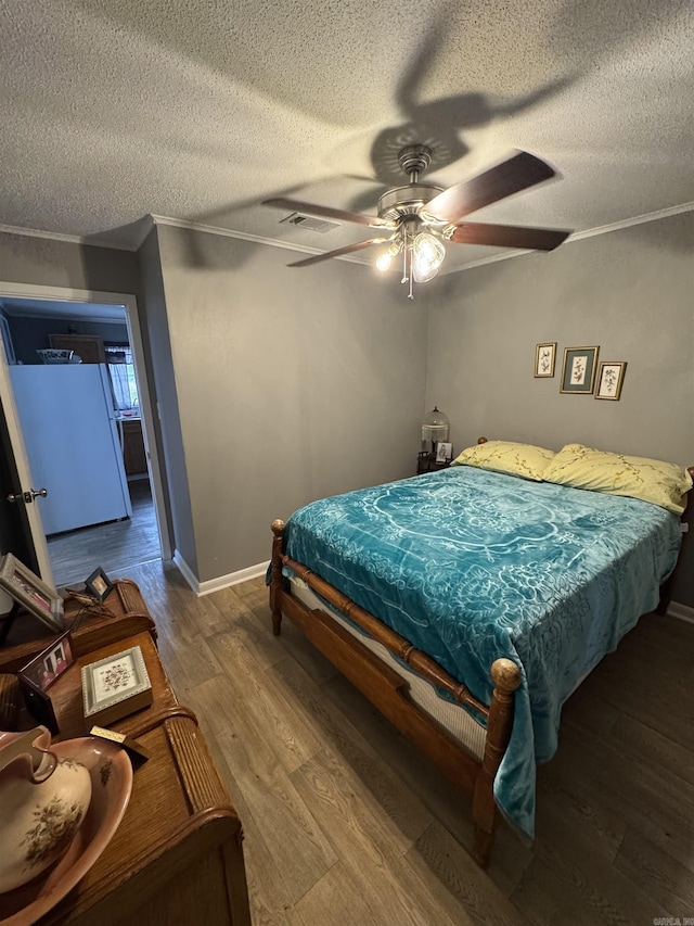 700 Thompson St, Mcgehee, AR 71654 - bedroom featuring visible vents, baseboards, ornamental molding, wood finished floors, and a textured ceiling