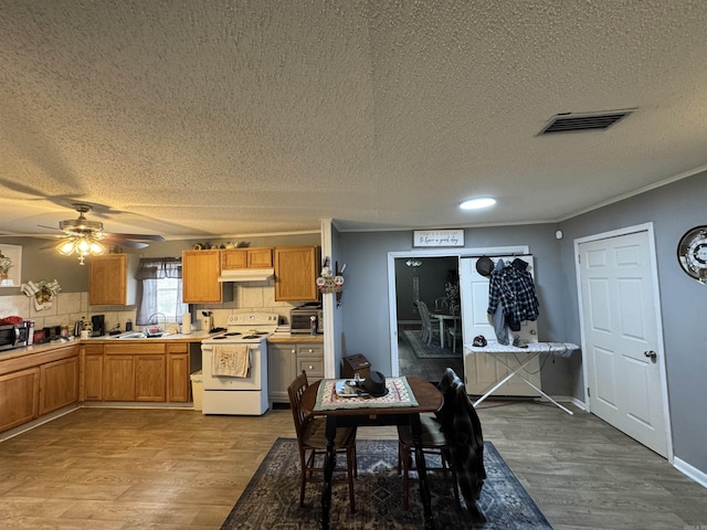 700 Thompson St, Mcgehee, AR 71654 - dining space with crown molding, wood finished floors, visible vents, and a textured ceiling