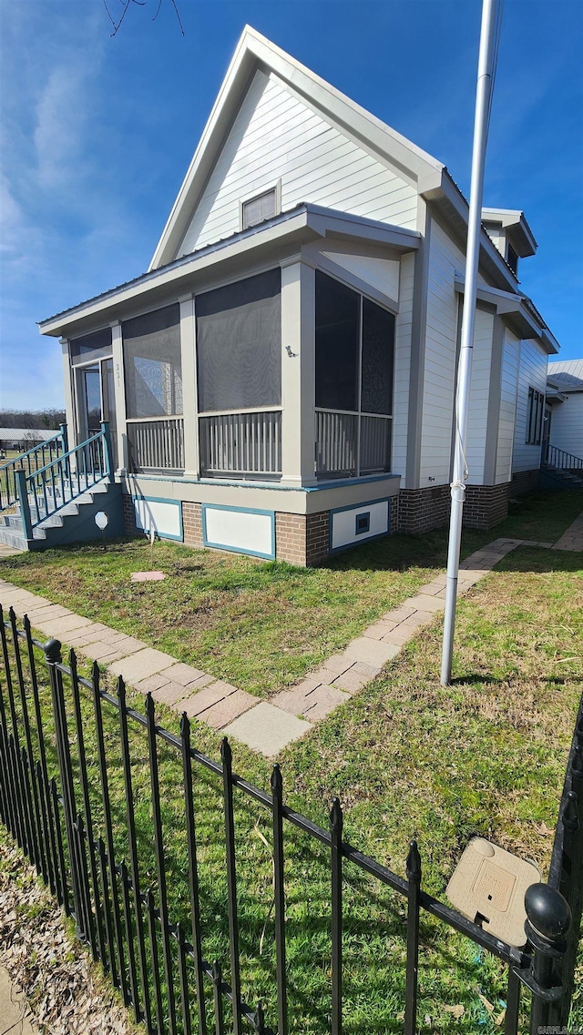 manufactured / mobile home with a fenced front yard, a front yard, and a sunroom