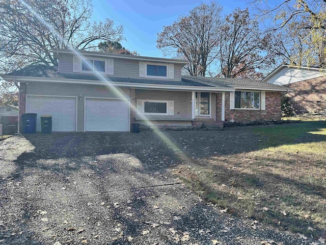 view of front facade featuring aphalt driveway, brick siding, and a front yard