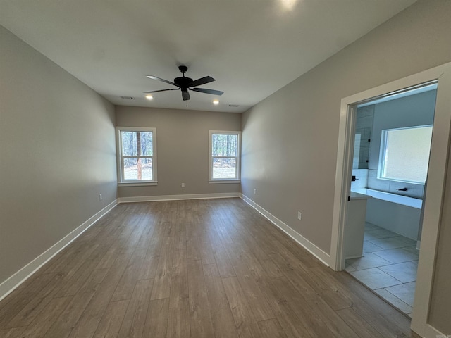 unfurnished room with dark wood-style floors, a ceiling fan, and baseboards