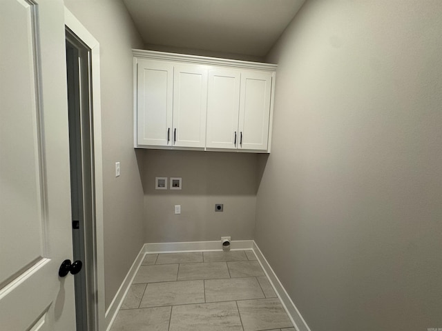 clothes washing area with cabinet space, hookup for a washing machine, hookup for an electric dryer, and baseboards