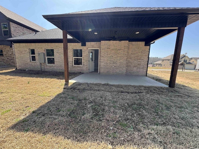 exterior space with a front yard, a patio area, brick siding, and ceiling fan