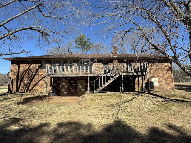 back of property with stairway, an attached garage, a wooden deck, brick siding, and a chimney