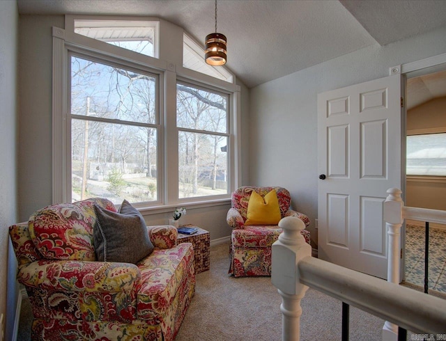 living area with an upstairs landing, carpet flooring, a textured ceiling, and vaulted ceiling