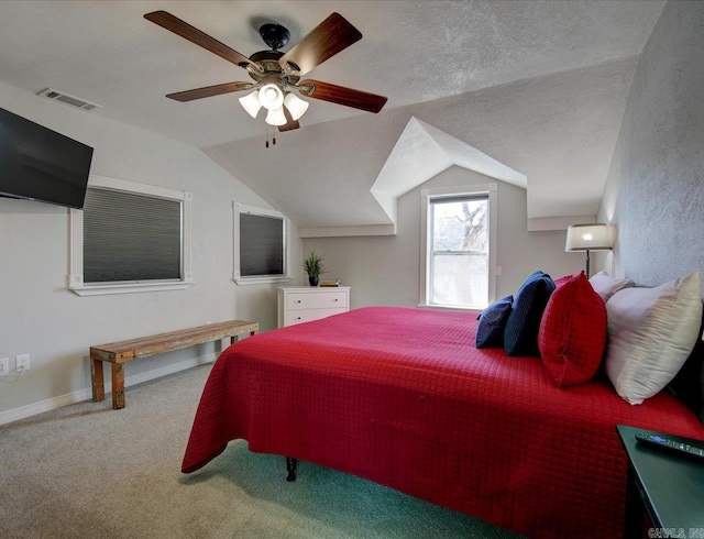 carpeted bedroom with visible vents, a textured ceiling, and vaulted ceiling