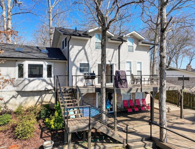 back of property featuring stairway, a deck, and fence