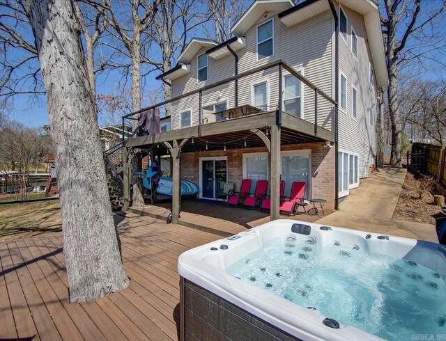 wooden terrace featuring a hot tub and fence