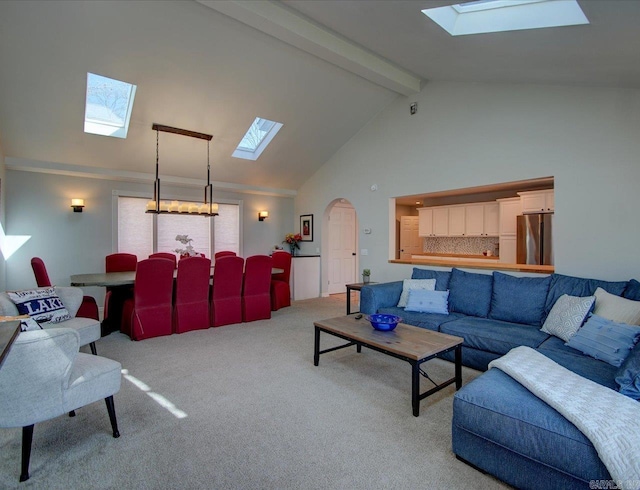 living area with beam ceiling, light carpet, a skylight, arched walkways, and high vaulted ceiling