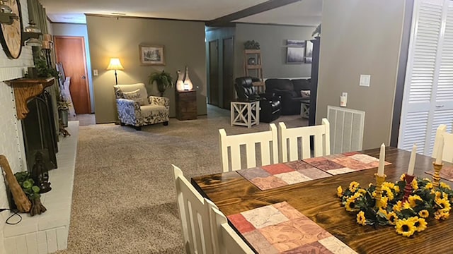 dining area featuring light colored carpet, visible vents, and a fireplace