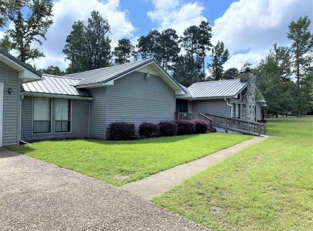 240 Timberlane Dr, Magnolia, AR 71753 - view of side of property featuring a chimney, a lawn, metal roof, and a standing seam roof