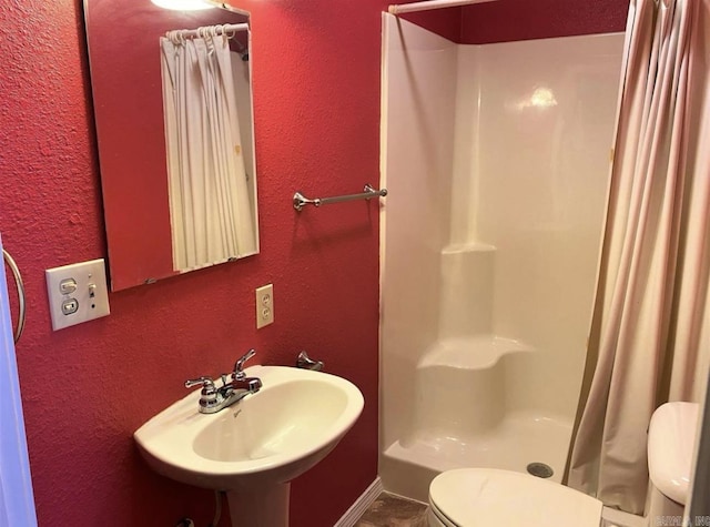 240 Timberlane Dr, Magnolia, AR 71753 - bathroom with a sink, toilet, a shower stall, and a textured wall