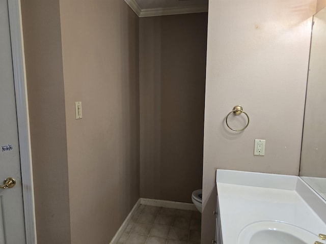 half bath with vanity, baseboards, ornamental molding, tile patterned floors, and toilet