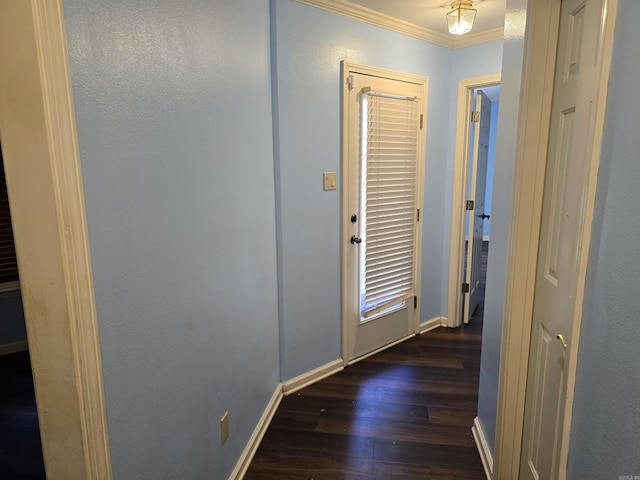 hallway featuring baseboards, crown molding, and dark wood-type flooring