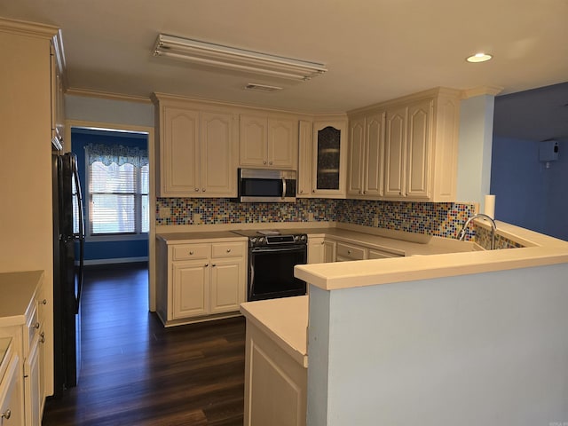 kitchen with visible vents, freestanding refrigerator, electric range oven, stainless steel microwave, and tasteful backsplash