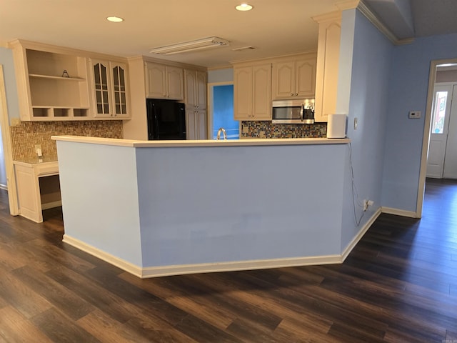 kitchen featuring dark wood-style floors, stainless steel microwave, black refrigerator, and open shelves