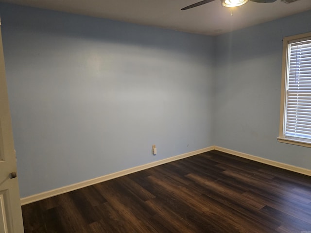unfurnished room featuring dark wood-style floors, baseboards, visible vents, and ceiling fan