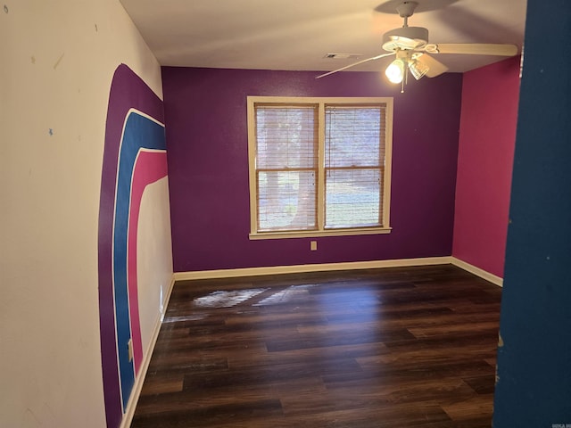 empty room featuring visible vents, baseboards, wood finished floors, and a ceiling fan