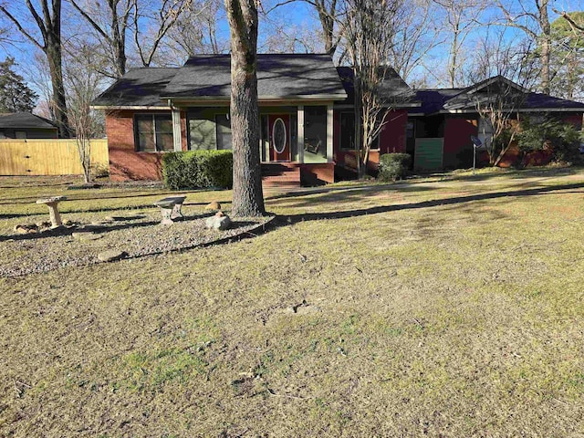 ranch-style house featuring a front yard and fence