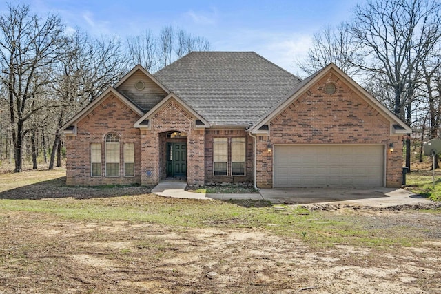 209 Round Mountain Rd, El Paso, AR 72045 - view of front of home with an attached garage, brick siding, driveway, and a shingled roof