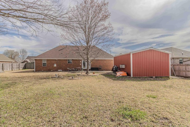 rear view of house with an outbuilding, a yard, a fenced backyard, and a patio